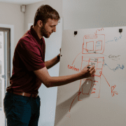 Man writing on whiteboard as part of PD Workshop. Credit Kaleidico