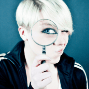 Do team-building programs work, woman looking through magnifying glass. Credit Emiliano Vittoriosi