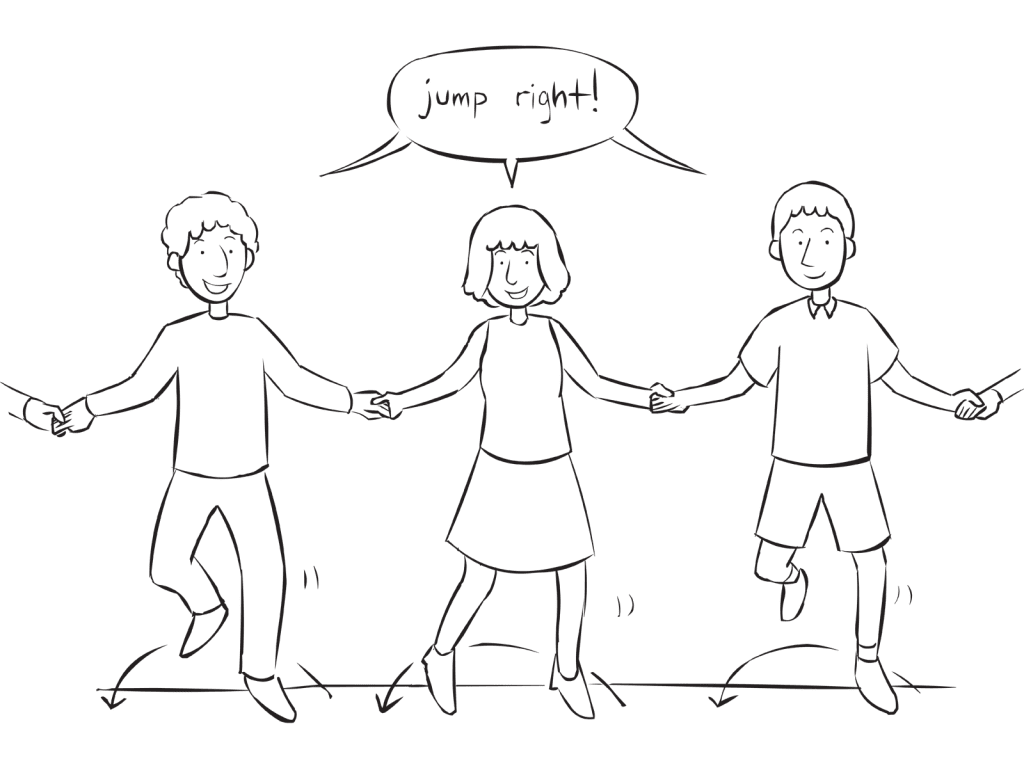People holding hands in a circle jumping to their right as part of interactive energiser game Jump In Jump Out