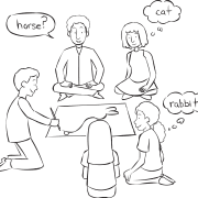 Man drawing an object in front of small group playing fun drawing game of Pictionary