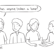 Fun team ice-breaker activity with four people sitting around a table writing on paper as they discuss many of their Commonalities