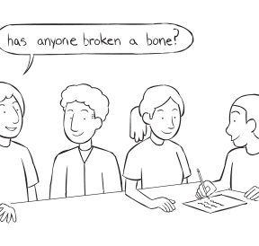 Fun team ice-breaker activity with four people sitting around a table writing on paper as they discuss many of their Commonalities