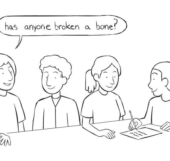 Fun team ice-breaker activity with four people sitting around a table writing on paper as they discuss many of their Commonalities