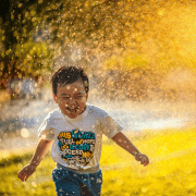 Boy running through sprinkler water game