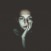 Woman sitting in dark with zoom fatigue. Credit Niklas Hamann
