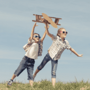 Power of fun with kids flying cardboard aeroplane