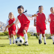 Young girls playing soccer showing how we practice