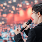 Woman speaking to large group wondering what to do with 150 people