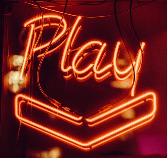 Neon sign displaying definition of play & program framework. Photo credit: Clem Onojeghuo