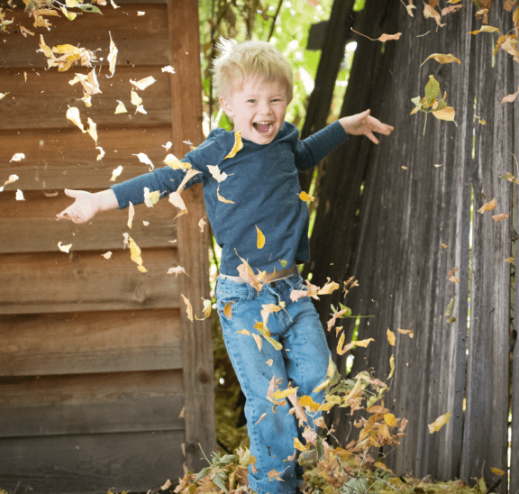 Boy playing with autumn leaves because play is making a comeback. Photo credit: Justin Young