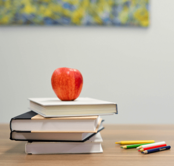 School books with apple to indicate back-to-school program time. Photo credit: Element5