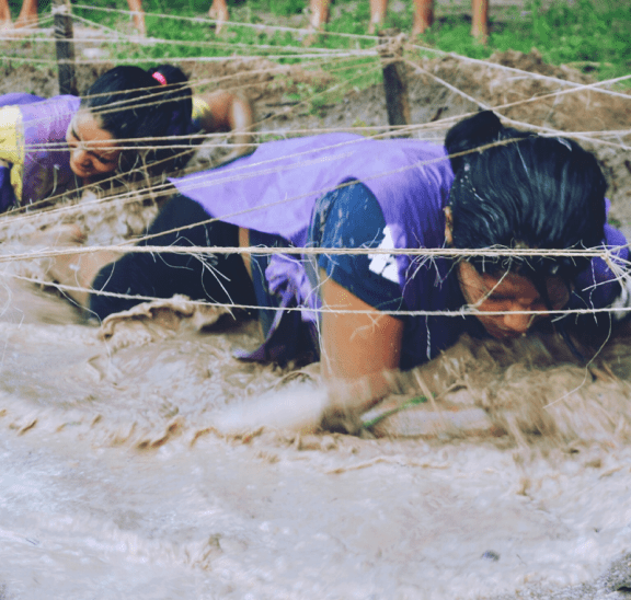Honouring Challenge by Choice - two women completing a mud crawl