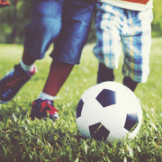 Two boys playing soccer portraying six simple principles of play