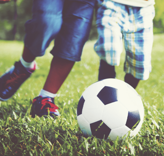 Two boys playing soccer portraying six simple principles of play