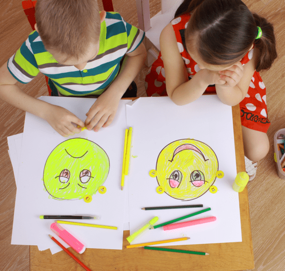 Children drawing emoji faces as part of SEL course